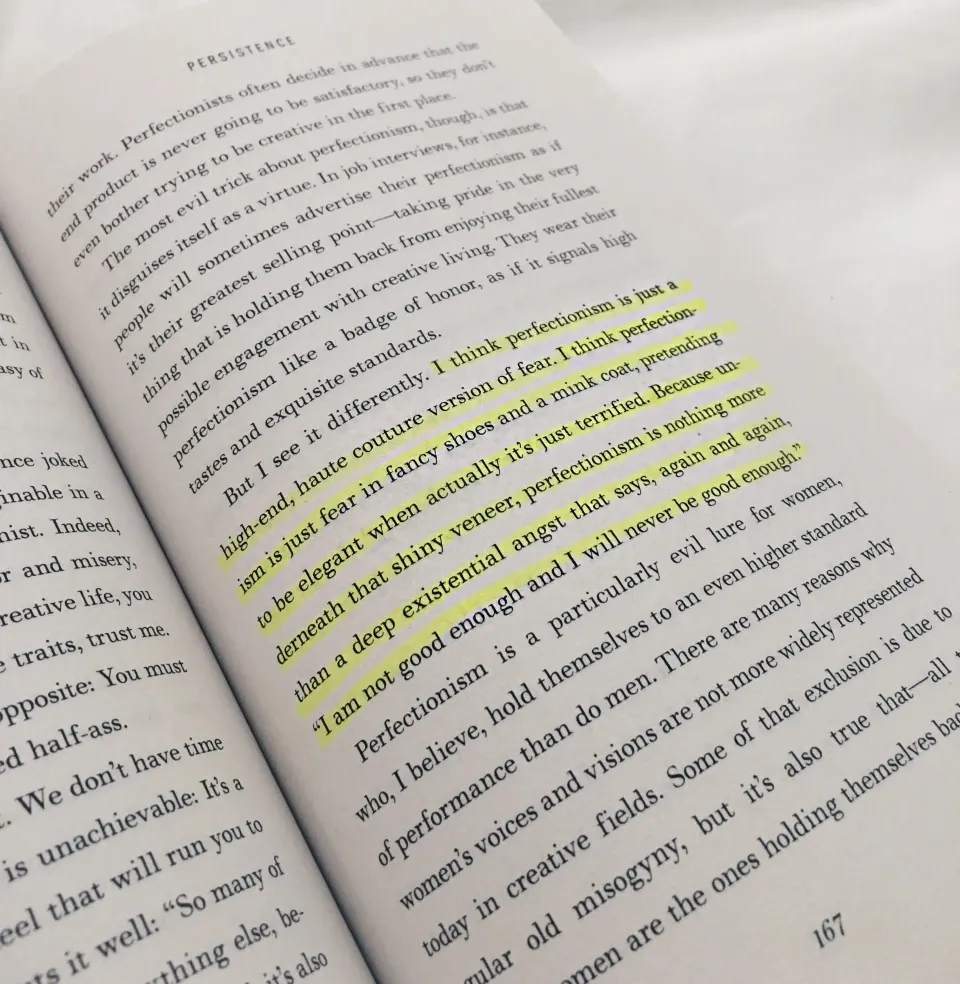 highlighted text from a paper book states I think perfectionism is just the high-end, haute couture version of fear. I think perfectionism is just fear in fancy shoes and a mink coat, pretending to be elegant when actually it's just terrified. Because underneath that shiny veneer, perfectionism is nothing more than a deep existential angst that says, again and again, "I am not good enough and I will never be good enough."